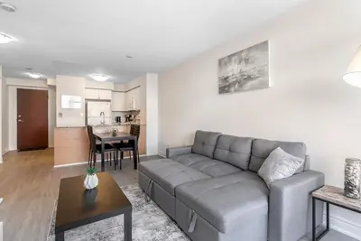 a living room with a gray couch and a table at Stylish 2BR with Great View! Steps from Square One in Mississauga