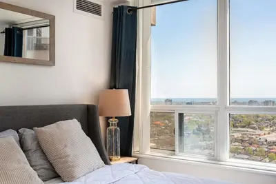 a bedroom with a bed and a window with a view at Stylish 2BR with Great View! Steps from Square One in Mississauga