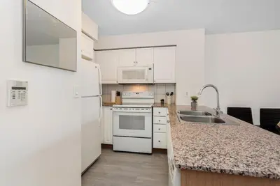 a kitchen with white appliances and a marble counter top at Stylish 2BR with Great View! Steps from Square One in Mississauga