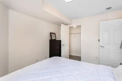 a white bedroom with a bed and a closet at Stylish 2BR with Great View! Steps from Square One in Mississauga