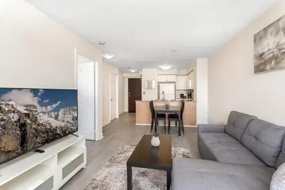 a living room with a couch and a tv at Stylish 2BR with Great View! Steps from Square One in Mississauga