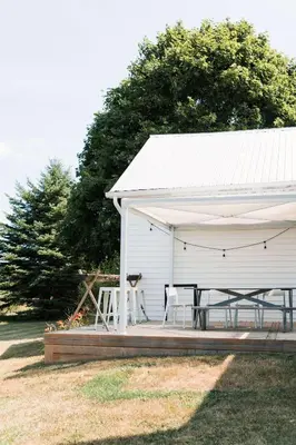 a white pavilion with a table and chairs under it at Babcock-Hubbs House in Carrying Place