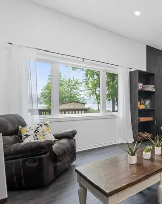 a living room with a leather couch and a large window at Lake lodge 6 in Frankford