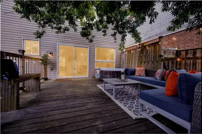 a patio with a blue couch on a wooden deck at Instaworthy Home - Relaxing Patio - Hot tub & BBQ in Cambridge