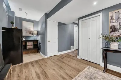 an empty living room with blue walls and a door at Instaworthy Home - Relaxing Patio - Hot tub & BBQ in Cambridge