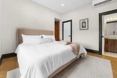 a bedroom with a large white bed and a window at The Wynford Elora The Monroe Suite in Elora