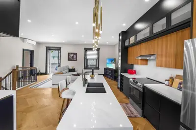 a kitchen with a white counter top and a living room at The Wynford Elora The Monroe Suite in Elora