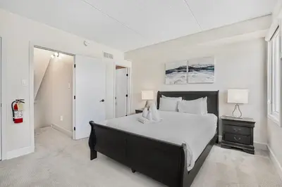 a bedroom with a large bed with white sheets and pillows at Blue Mountain Haus - Private Patio - Walk to Blue in Blue Mountains