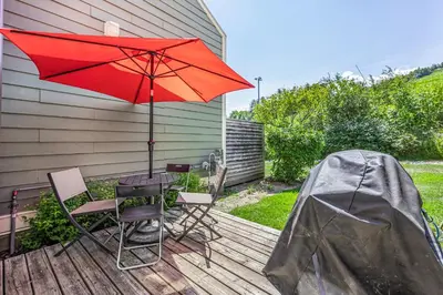 a patio with a table and a red umbrella at Blue Mountain Haus - Private Patio - Walk to Blue in Blue Mountains