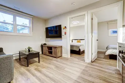 a living room with a bed and a tv at Adrian's Suites 2 Bedroom Family Suite in Wasaga Beach