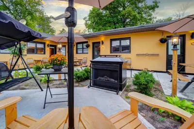 a patio with a fireplace and tables and an umbrella at Adrian's Suites 2 Bedroom Family Suite in Wasaga Beach