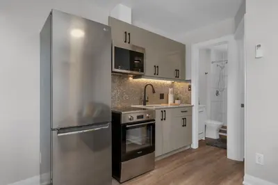a kitchen with a stainless steel refrigerator and a sink at Adrian's Suites 1 Bedroom Junior Suite in Wasaga Beach