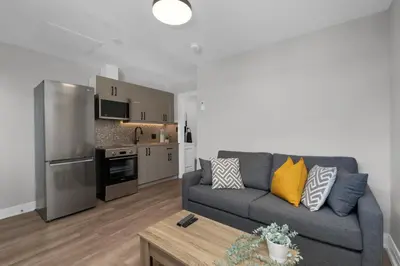 a living room with a couch and a kitchen at Adrian's Suites 1 Bedroom Junior Suite in Wasaga Beach