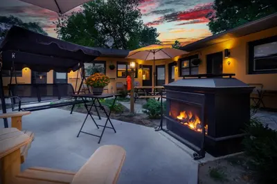 a backyard with a fireplace and a table and an umbrella at Adrian's Suites 1 Bedroom Junior Suite in Wasaga Beach