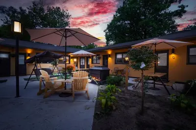 a patio with a table and chairs and umbrellas at Adrian's Suites 1 Bedroom Junior Suite in Wasaga Beach