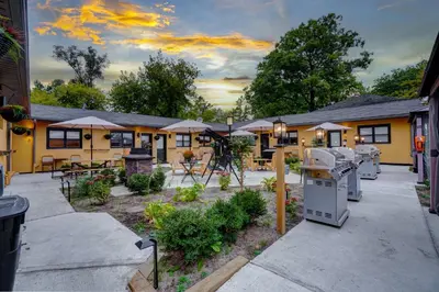a building with a patio with tables and umbrellas at Adrian's Suites 1 Bedroom Junior Suite in Wasaga Beach