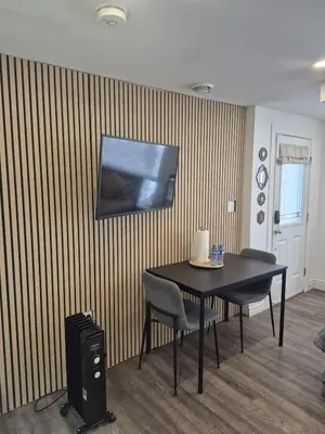 a room with a table and chairs and a television on the wall at Compact,1BR Guesthouse Studio in Guelph
