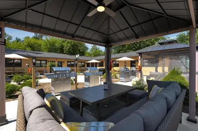 an outdoor patio with a table and a grill at Adrian's Suites 2Bedroom Family Suite in Wasaga Beach