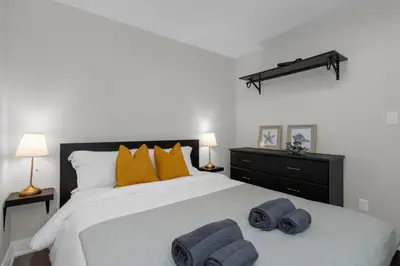 a bedroom with a large bed with towels on it at Adrian's Suites 2 Bedroom Family Suite in Wasaga Beach