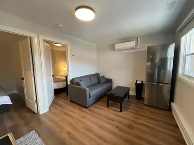 a living room with a couch and a refrigerator at Adrian's Suites 2 Bedroom Family Suite in Wasaga Beach