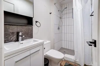 a white bathroom with a toilet and a shower at Adrian's Suites 1Bedroom Junior Suite in Wasaga Beach