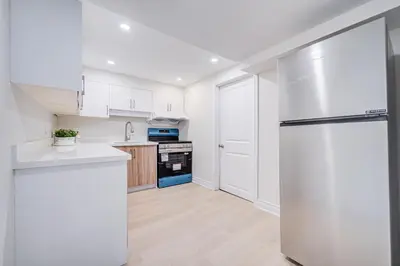 a kitchen with white cabinets and a refrigerator at nest in orchard-main unit room in Toronto