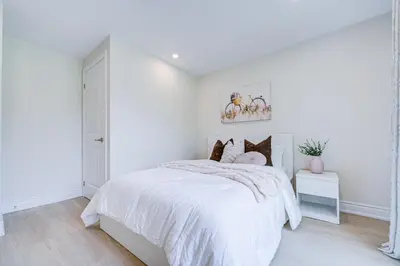 a white bedroom with a white bed with pillows at nest in orchard-main unit room in Toronto