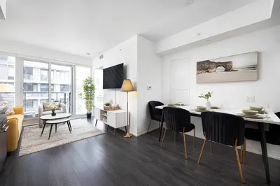 a living room and dining room with a table and chairs at 2br Luxury & Modern Suite 5 Minutes from Eaton Center in Toronto