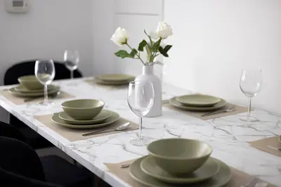 a table with plates and glasses and a vase with flowers at 2br Luxury & Modern Suite 5 Minutes from Eaton Center in Toronto