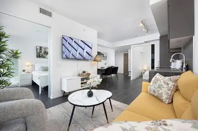 a living room with a couch and a table at 2br Luxury & Modern Suite 5 Minutes from Eaton Center in Toronto