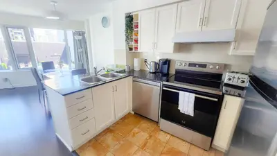 a kitchen with white cabinets and a black stove top oven at Pantages Skyline Suite in Toronto Centre - Free Parking in Toronto