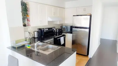 a kitchen with a sink and a refrigerator at Pantages Skyline Suite in Toronto Centre - Free Parking in Toronto