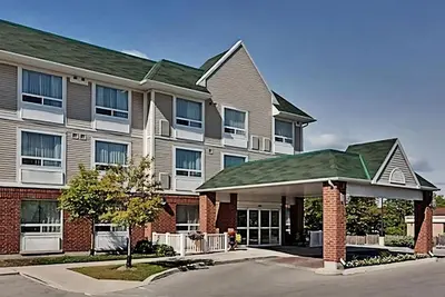 a large apartment building with a gazebo in front of it at Staywell Inn & Suites in London