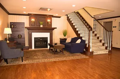 a living room with a couch and a fireplace at Staywell Inn & Suites in London
