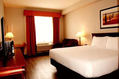 a hotel room with a bed and a window at Staywell Inn & Suites in London
