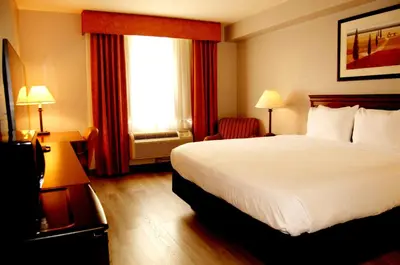 a hotel room with a bed and a window at Staywell Inn & Suites in London