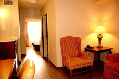 a living room with a chair and a lamp at Staywell Inn & Suites in London