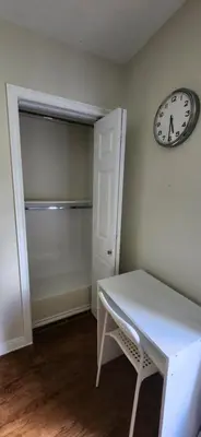 a room with a white table and a clock on the wall at Sunny Corner Room with View in Toronto