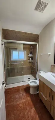 a bathroom with a shower and a toilet and a sink at Sunny Corner Room with View in Toronto