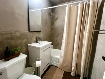 a bathroom with a toilet and a sink and a shower at Cozy Upper Beaches Apartment in Toronto