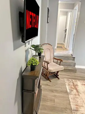 a living room with a tv on a wall at Cozy Retreat with Netflix and Work Desk in Fort Erie