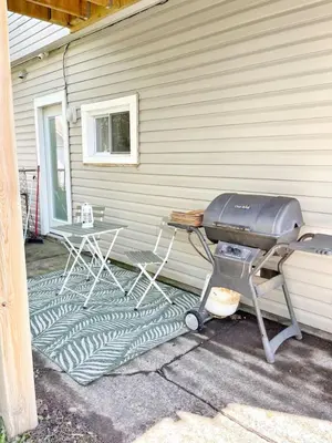 a grill sitting on the side of a house at Cozy Retreat with Netflix and Work Desk in Fort Erie