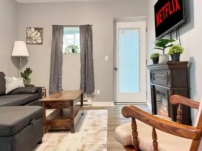 a living room with a couch and a table at Cozy Retreat with Netflix and Work Desk in Fort Erie