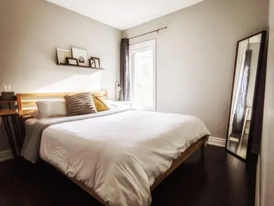 a bedroom with a large white bed with a window at Inviting 2BR Townhouse with 2 WFH Setups and WiFi in Toronto