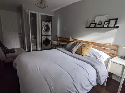 a bedroom with a large bed and a washing machine at Inviting 2BR Townhouse with 2 WFH Setups and WiFi in Toronto
