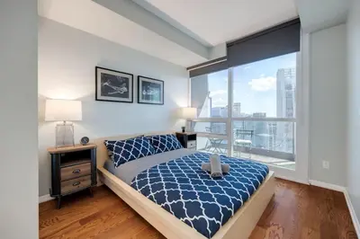 a bedroom with a bed and a large window at Ent District 3 Bedroom 2Bath Parking CN Tower in Toronto