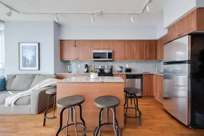a kitchen with wooden cabinets and a kitchen island with bar stools at Ent District 3 Bedroom 2Bath Parking CN Tower in Toronto