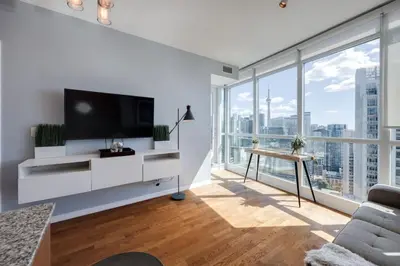 a living room with a tv and large windows at Ent District 3 Bedroom 2Bath Parking CN Tower in Toronto