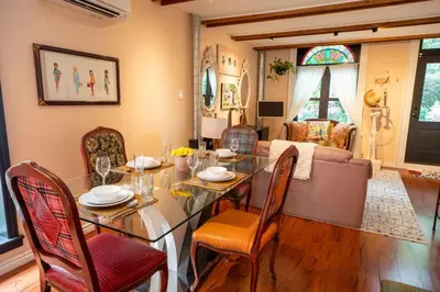a dining room with a table and chairs and a couch at Stylish 2BR Home with Front Yard and Free Parking in Toronto