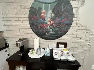 a table with a coffee maker and a vase on a wall at Beautiful home, a few minutes to the waterfall and attractions in Niagara Falls